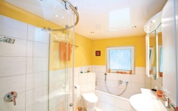 Белый глянцевый натяжной потолок в ванную с точечными светильниками