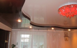 Криволинейный двухуровневый натяжной потолок в гостиную