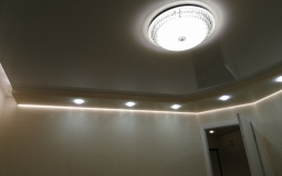 Двухуровневый натяжной потолок в гостиную с точечными светильниками.