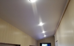 Белый натяжной потолок в коридоре с точечным освещением
