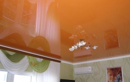 Глянцевый оранжевый натяжной потолок в гостиной